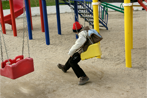 Boy sitting alone in a playground